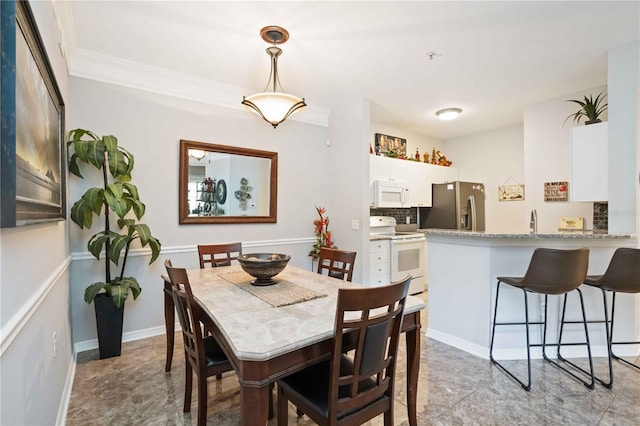 dining room featuring baseboards and ornamental molding