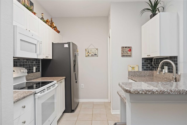 kitchen featuring white appliances, white cabinets, light stone counters, backsplash, and light tile patterned flooring