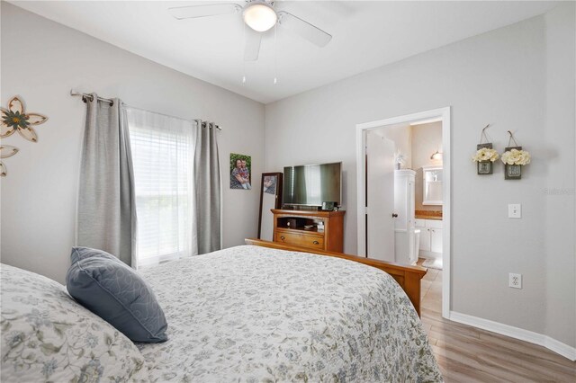 bedroom featuring ceiling fan, ensuite bath, and hardwood / wood-style flooring