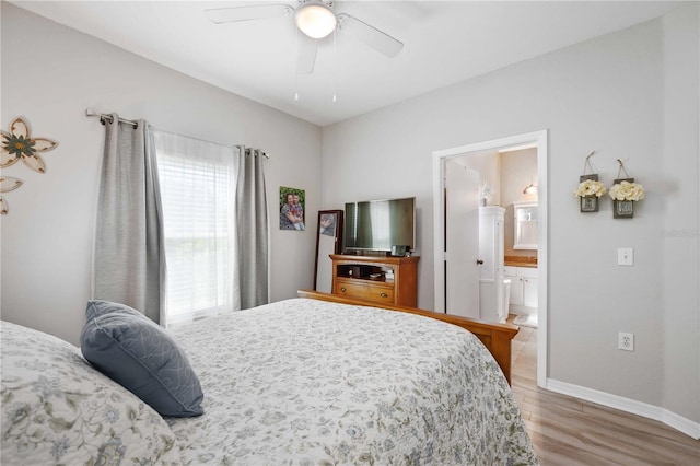 bedroom featuring ceiling fan, baseboards, wood finished floors, and ensuite bathroom