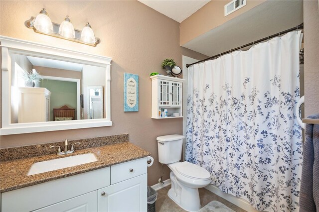 bathroom with tile patterned flooring, toilet, vanity, and curtained shower