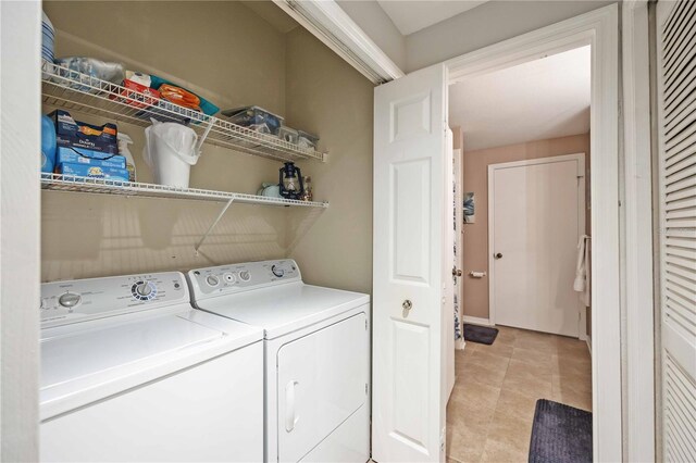 clothes washing area with light tile patterned floors and washing machine and clothes dryer