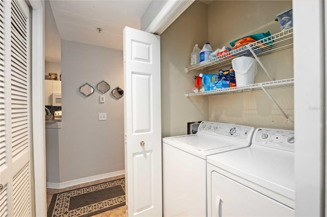 laundry room featuring laundry area, baseboards, and washing machine and clothes dryer