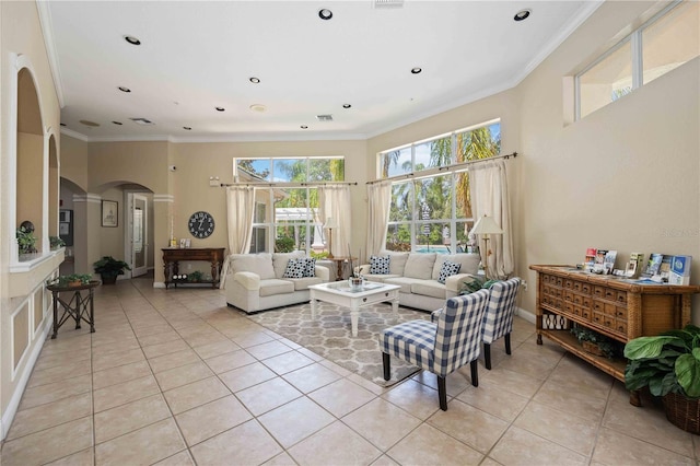 living area featuring light tile patterned floors, visible vents, arched walkways, and ornamental molding