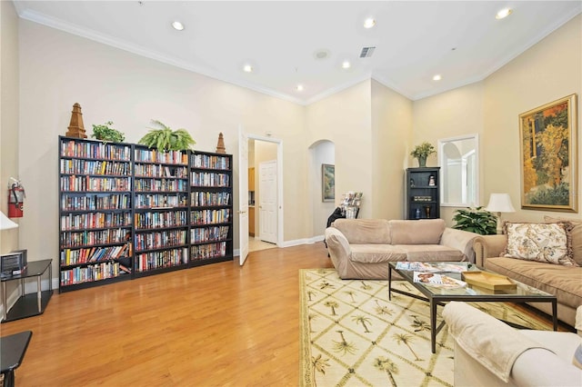 living room featuring light hardwood / wood-style flooring and crown molding