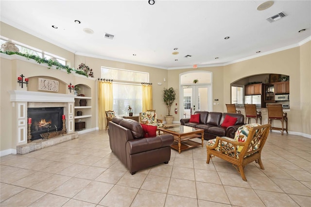 tiled living room featuring built in features, french doors, and crown molding