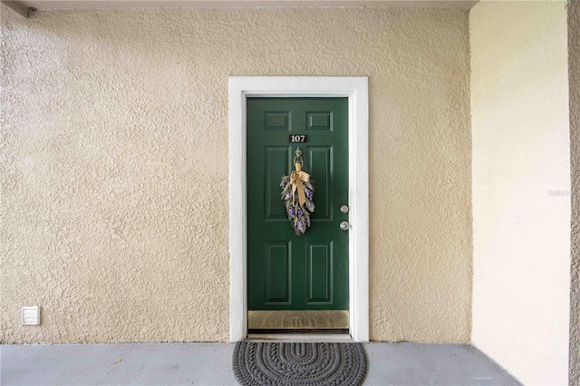 entrance to property featuring stucco siding