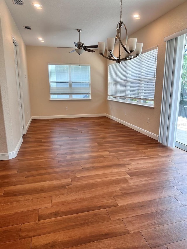 interior space with hardwood / wood-style floors and ceiling fan with notable chandelier