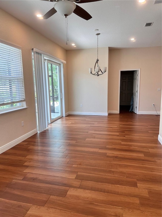 unfurnished room featuring ceiling fan with notable chandelier and wood-type flooring