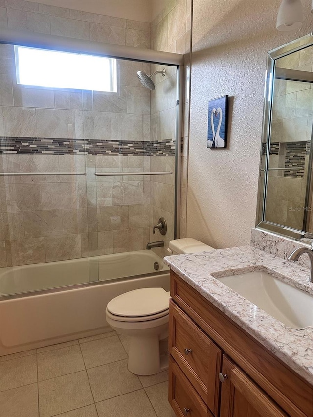 full bathroom with tile patterned flooring, toilet, vanity, and enclosed tub / shower combo