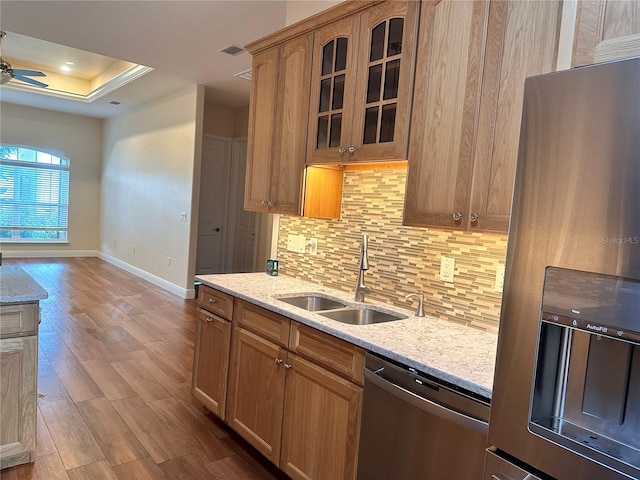 kitchen featuring backsplash, sink, light hardwood / wood-style flooring, ceiling fan, and stainless steel appliances