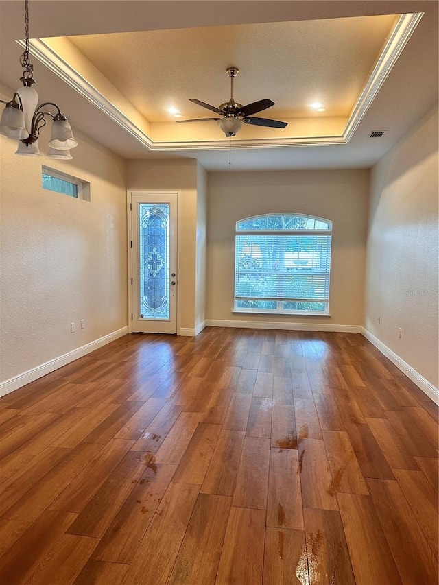 unfurnished living room featuring ceiling fan, a raised ceiling, and hardwood / wood-style floors