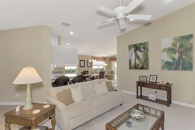 living area with light colored carpet, ceiling fan with notable chandelier, recessed lighting, visible vents, and baseboards