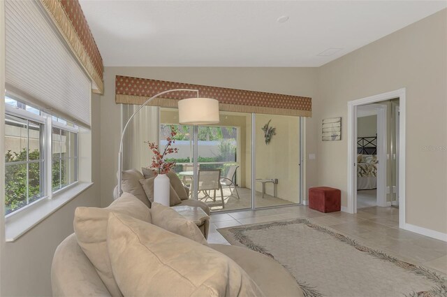 tiled living room featuring lofted ceiling and a healthy amount of sunlight