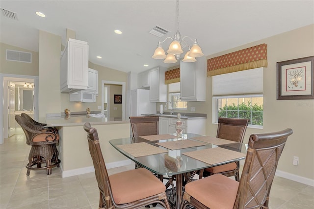 dining room featuring lofted ceiling, visible vents, and an inviting chandelier