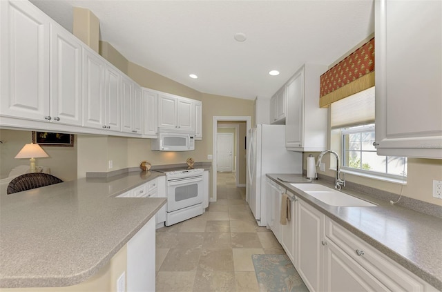 kitchen featuring a peninsula, white appliances, and white cabinets