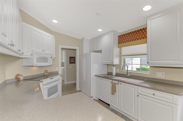 kitchen with white cabinets, white appliances, vaulted ceiling, and sink