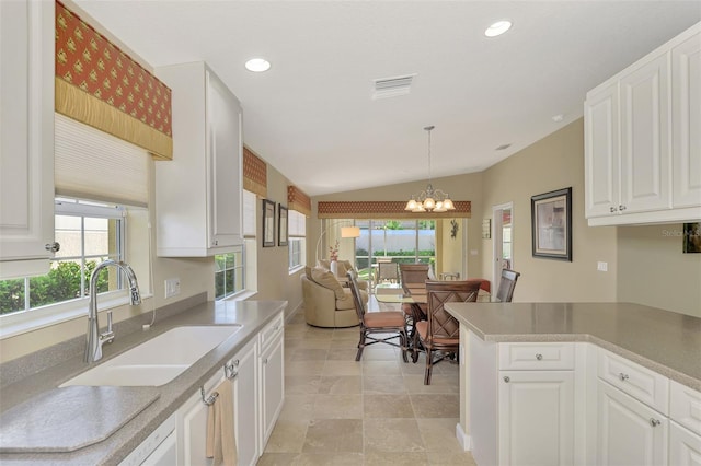 kitchen featuring a healthy amount of sunlight, sink, a notable chandelier, and hanging light fixtures