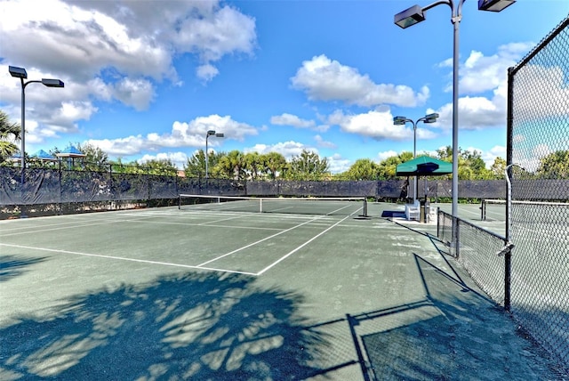 view of tennis court featuring fence