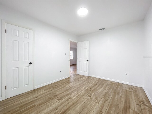 unfurnished room with light wood-type flooring