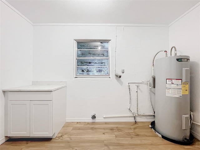 clothes washing area featuring water heater, cabinets, ornamental molding, and light hardwood / wood-style flooring