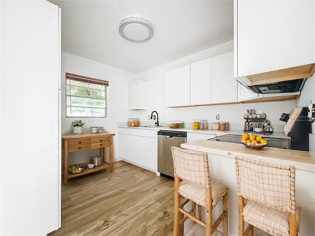 kitchen with white cabinets, light hardwood / wood-style floors, stainless steel dishwasher, and sink