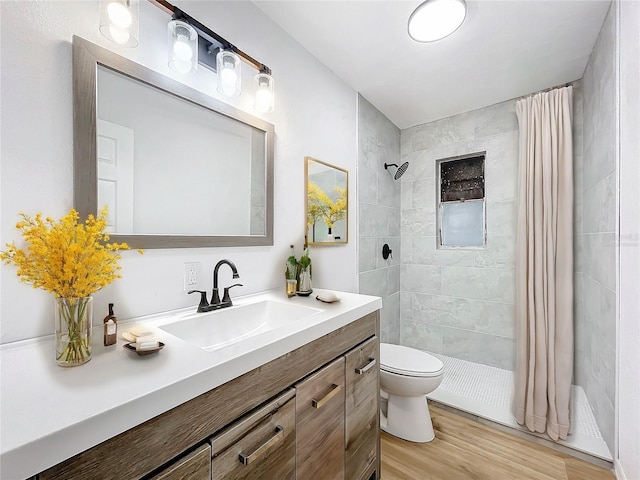 bathroom featuring toilet, hardwood / wood-style flooring, a shower with shower curtain, and vanity