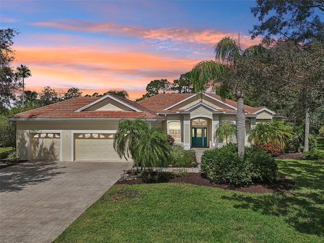 view of front of home with a lawn and a garage