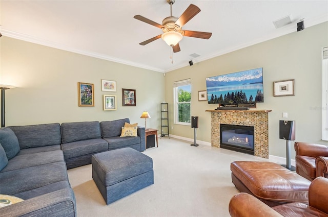 living room with ceiling fan, crown molding, light carpet, and a tile fireplace