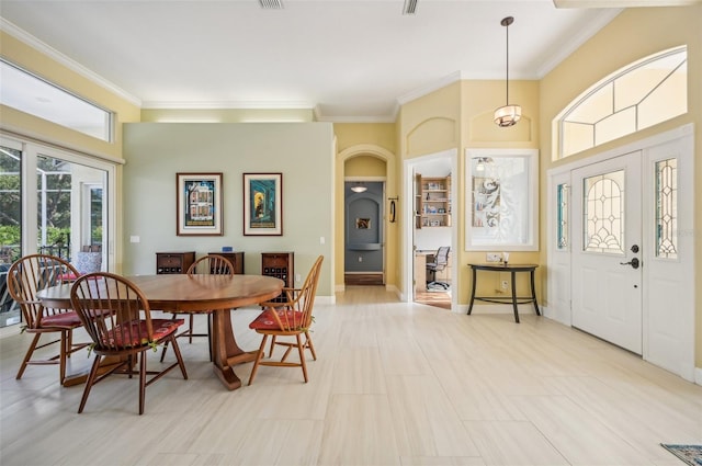 dining room featuring light tile patterned floors and crown molding