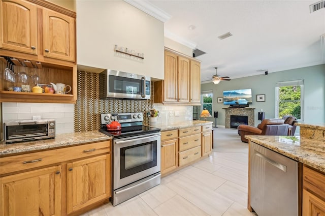 kitchen featuring appliances with stainless steel finishes, tasteful backsplash, light stone countertops, light tile patterned floors, and ceiling fan