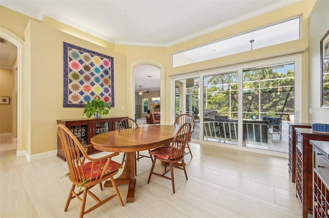 tiled dining space featuring ceiling fan and crown molding