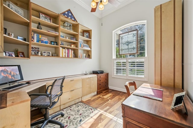 home office featuring ornamental molding, vaulted ceiling, light wood-type flooring, built in desk, and ceiling fan