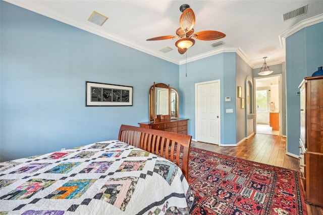 bedroom with ceiling fan, ornamental molding, and wood-type flooring