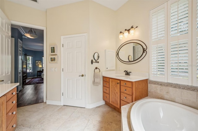 bathroom featuring tiled tub, vanity, and wood-type flooring