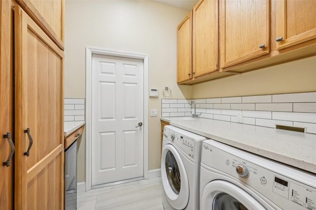 laundry room featuring independent washer and dryer and cabinets