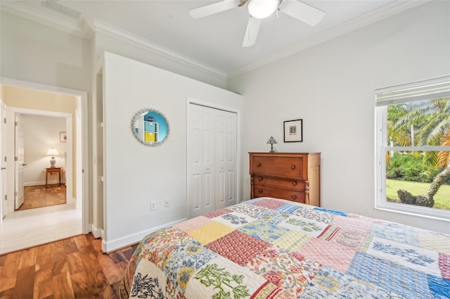 tiled bedroom with ceiling fan, crown molding, and a closet