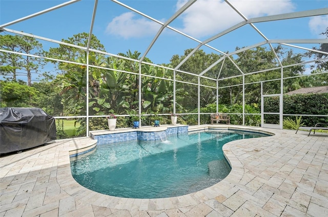 view of pool with pool water feature, glass enclosure, a grill, and a patio