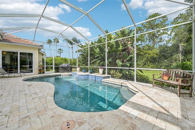 view of pool featuring a hot tub, a lanai, pool water feature, and a patio area