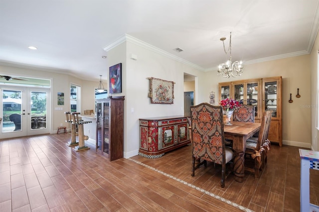 dining space featuring ornamental molding, dark hardwood / wood-style floors, ceiling fan with notable chandelier, and french doors