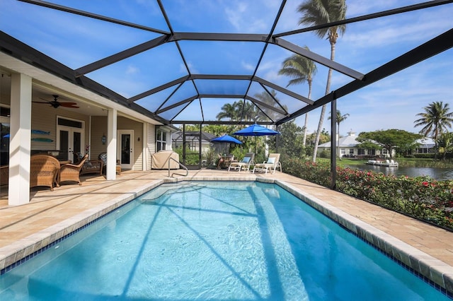 view of swimming pool featuring a lanai, a water view, ceiling fan, and a patio