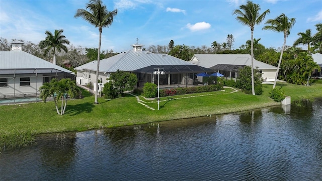 rear view of house featuring a yard, a water view, and glass enclosure