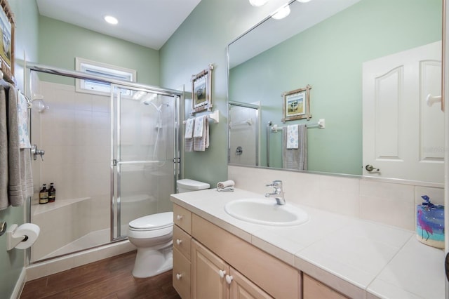 bathroom featuring walk in shower, vanity, toilet, and hardwood / wood-style floors