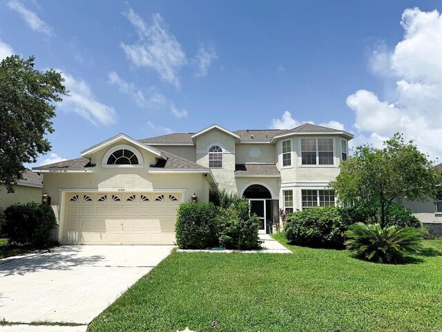 view of front of property with a garage and a front lawn