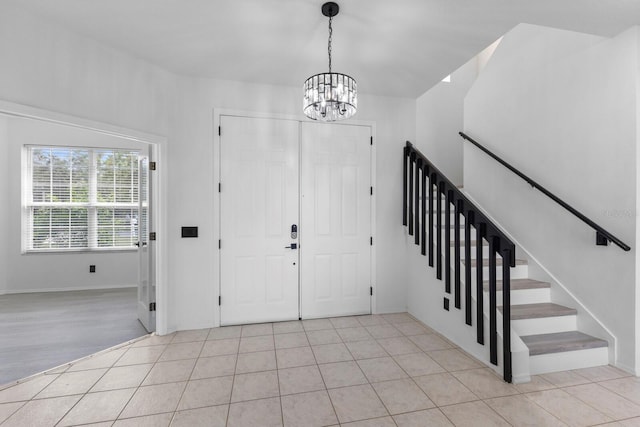 foyer featuring stairway, a notable chandelier, and light tile patterned flooring