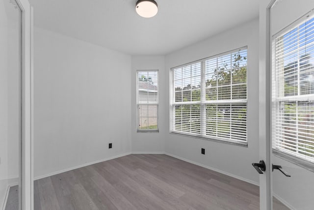 spare room featuring light wood-type flooring and baseboards