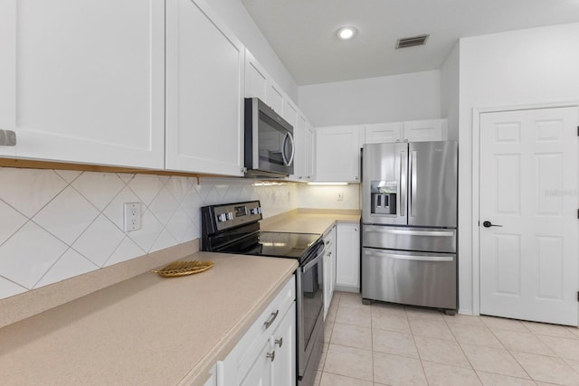 kitchen with light countertops, appliances with stainless steel finishes, decorative backsplash, and white cabinets