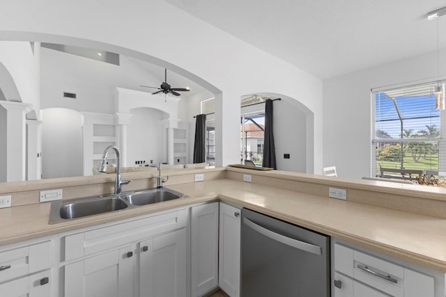 kitchen featuring light countertops, white cabinetry, a sink, dishwasher, and ornate columns