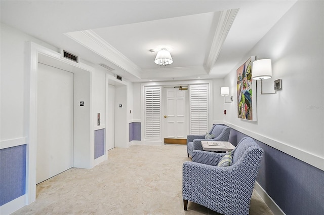 sitting room with crown molding, elevator, and a tray ceiling