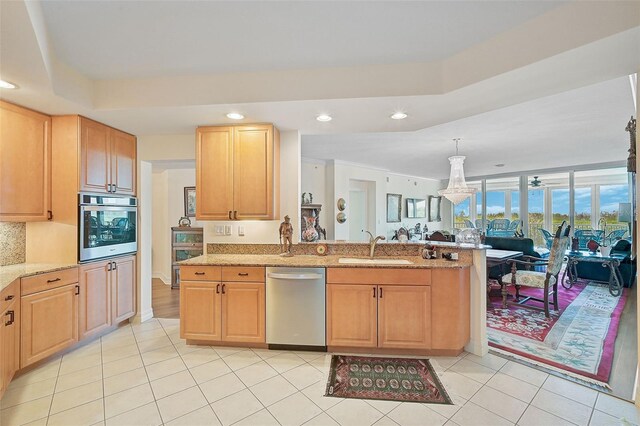 kitchen featuring stainless steel appliances, sink, light brown cabinets, kitchen peninsula, and light tile patterned flooring